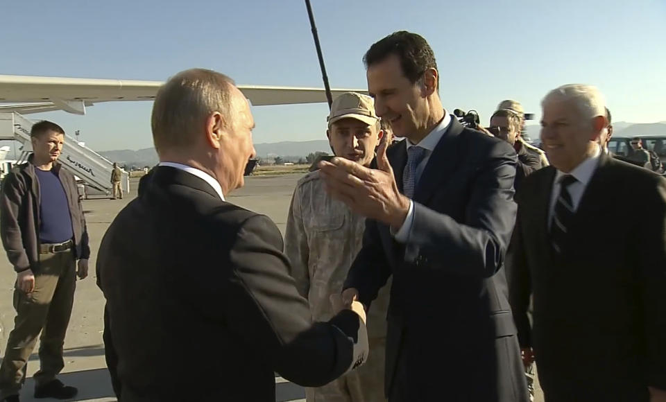 FILE - In this Monday, Dec. 11, 2017 file frame grab made available by Russian Presidential TV Syrian President Bashar Assad, right, greets Russian President Vladimir Putin upon his arrival to the Hemeimeem air base in Syria. Assad has survived years of war and millions of dollars in money and weapons aimed at toppling him. Now after nearly eight years of conflict, he is poised to be readmitted to the fold of Arab nations, a feat once deemed unthinkable as he brutally crushed a years-long uprising against his family’s rule. (Presidential TV photo via AP, File)