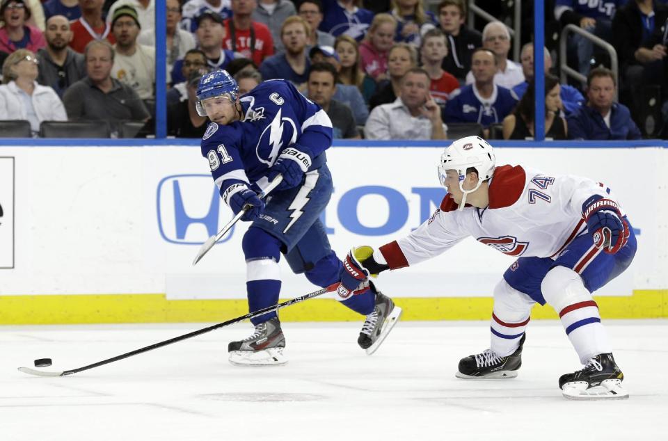 Tampa Bay Lightning center Steven Stamkos (91) fires the puck past Montreal Canadiens defenseman Alexei Emelin (74), of Russia, for a goal during the second period of Game 1 of a first-round NHL hockey playoff series on Wednesday, April 16, 2014, in Tampa, Fla. (AP Photo/Chris O'Meara)