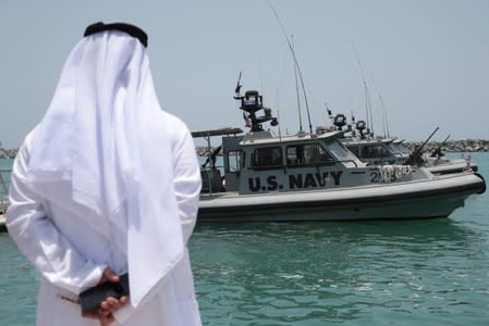 An Emirati official watches members of the U.S. Navy Fifth Fleet as they prepare to escort journalists to the Japanese-owned Kokuka Courageous tanker at a U.S. NAVCENT facility near the port of Fujairah