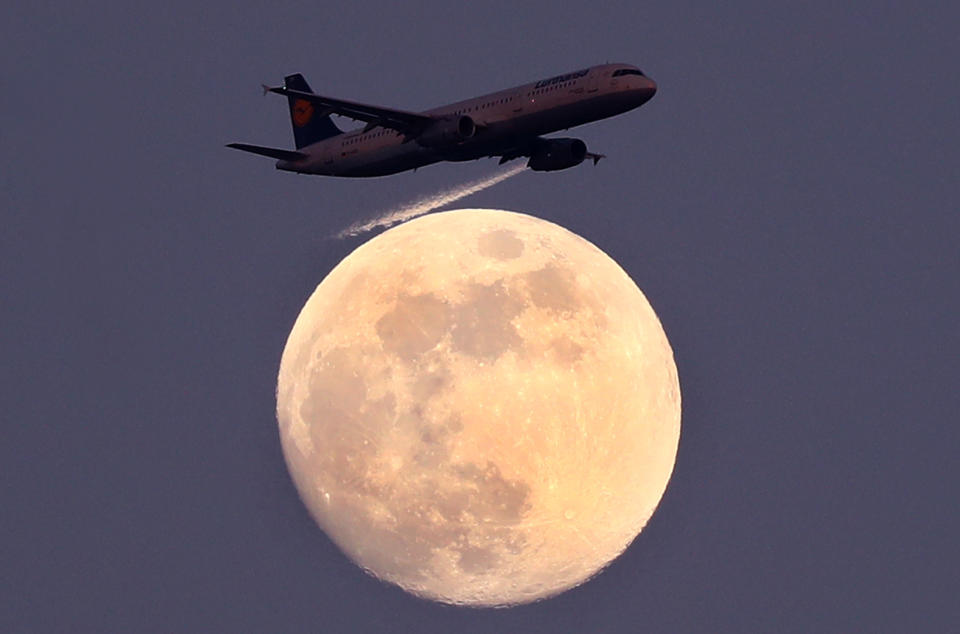 An airplane of German air carrier Lufthansa passes the moon over Frankfurt, Germany, April 9, 2017.  REUTERS/Kai Pfaffenbach      TPX IMAGES OF THE DAY