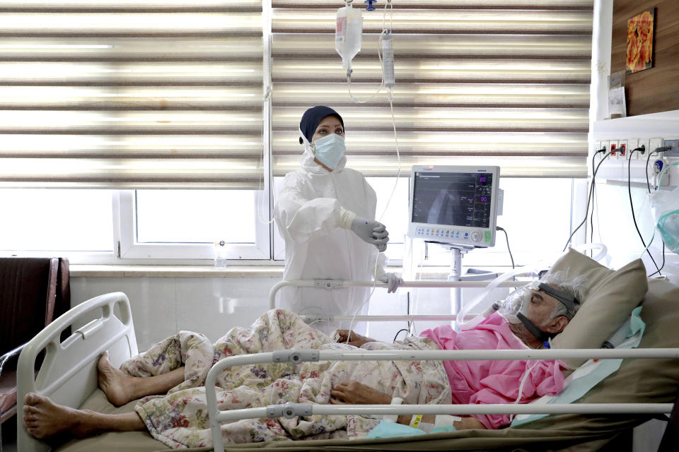 A nurse tends to a COVID-19 patient, at the Shohadaye Tajrish Hospital in Tehran, Iran, Sunday, April 18, 2021. After facing criticism for downplaying the virus last year, Iranian authorities have put partial lockdowns and other measures in place to try and slow the coronavirus’ spread. (AP Photo/Ebrahim Noroozi)