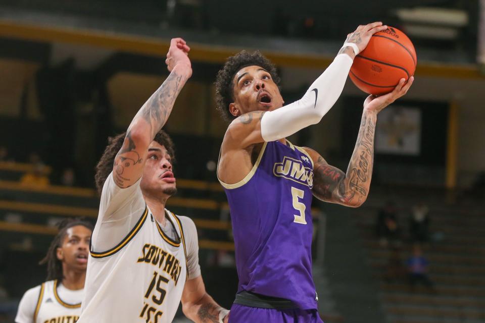 Jan 6, 2024; Hattiesburg, Mississippi, USA; James Madison Dukes guard Terrence Edwards Jr. (5) is defended by Southern Miss Golden Eagles guard Donovan Ivory (15) during the first half at Reed Green Coliseum. Mandatory Credit: Chuck Cook-USA TODAY Sports