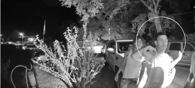 A video of a home invasion shows an unidentified suspect, circled, in Pensacola, Fla., on July 7, 2022, who police say pulled a handgun from his pants during the incident. (Escambia County Sheriff's Office)