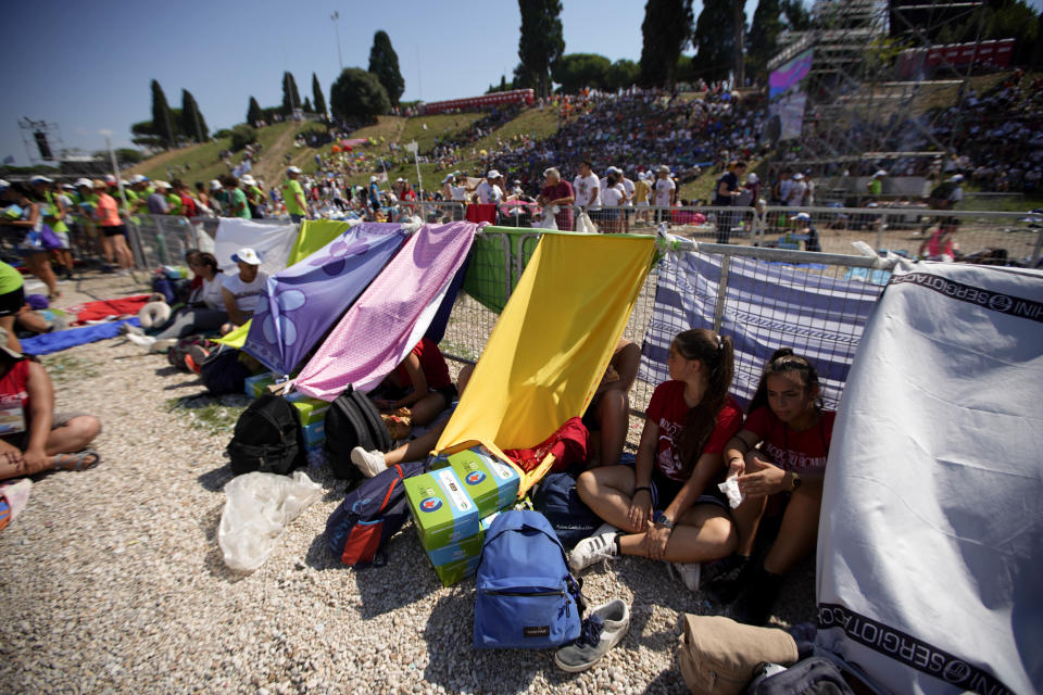 Faithful gather in Rome's Circus Maximus as they wait for the arrival of Pope Francis to lead an evening prayer vigil with youths, Saturday, Aug. 11, 2018. Thousand of youths gathered for the meeting with the pontiff in preparation for the next World Youth Day that will be held in Panama next year. (AP Photo/Andrew Medichini)