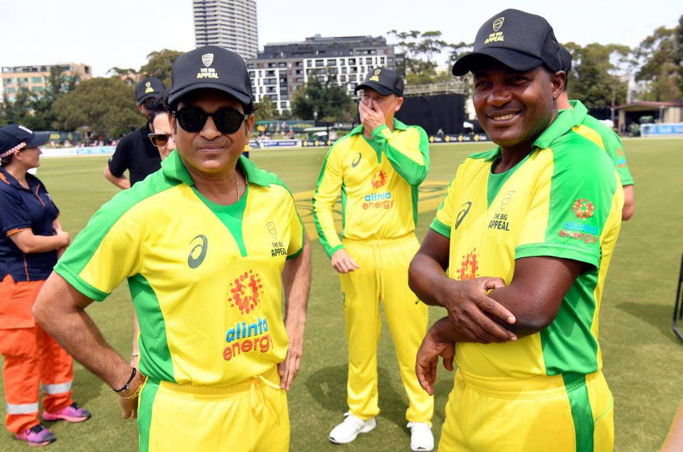 Former Indian cricket player Sachin Tendulkar (L) smiles and speaks with former West Indies player Brian Lara (R).