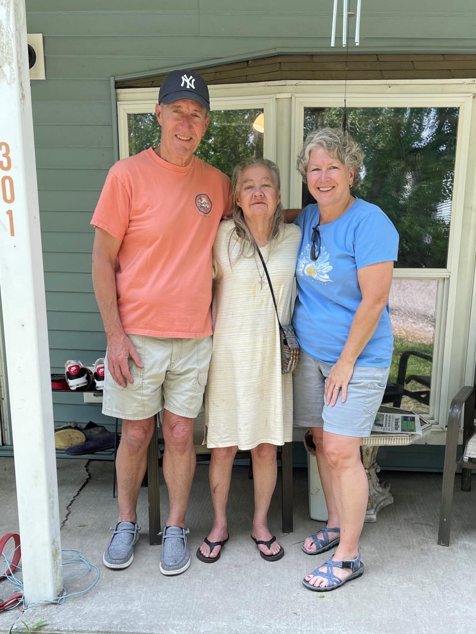 Barb and John Fox stand beside Sylvia on her front porch. They have been working together for almost two years.