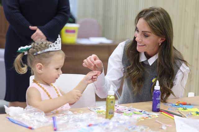 <p>Chris Jackson/Getty</p> Kate Middleton crafts with a young girl at Vsi Razom Community Hub