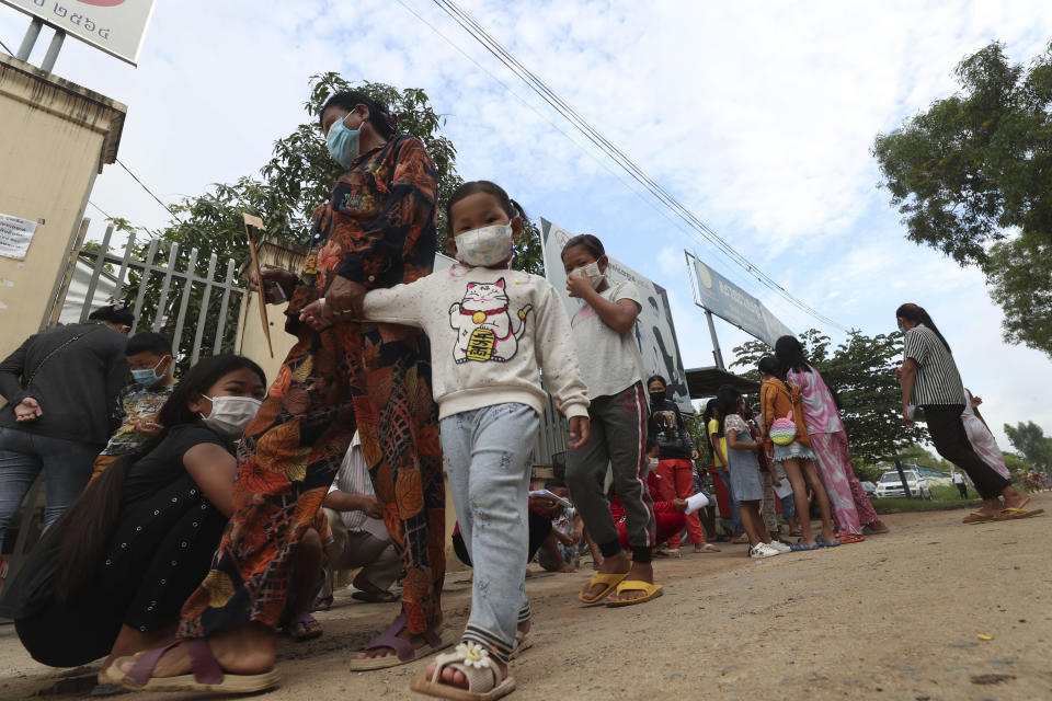 Children wait in front of Samrong Krom health center before receiving a shot of the Sinovac's COVID-19 vaccine at outside Phnom Penh, Cambodia, Friday, Sept. 17, 2021. Prime Minister Hun Sen announced the start of a nationwide campaign to give COVID-19 vaccinations to children between the ages of 6 and 11 so they can return to school safely after a long absence due to measures taken against the spread of the coronavirus. (AP Photo/Heng Sinith)