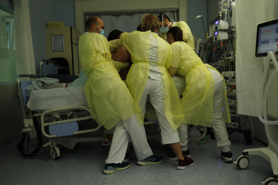 Nurse Anne-Catherine Charlier, right, and co-workers, wearing personal protection equipment, work in the intensive care ward for COVID-19 patients at the CHR Citadelle hospital in Liege, Belgium, Wednesday, Dec. 16, 2020. Belgium has been hit hard by the pandemic with more than 18,000 confirmed deaths. The patient was not confirmed but suspected to have coronavirus. (AP Photo/Francisco Seco)