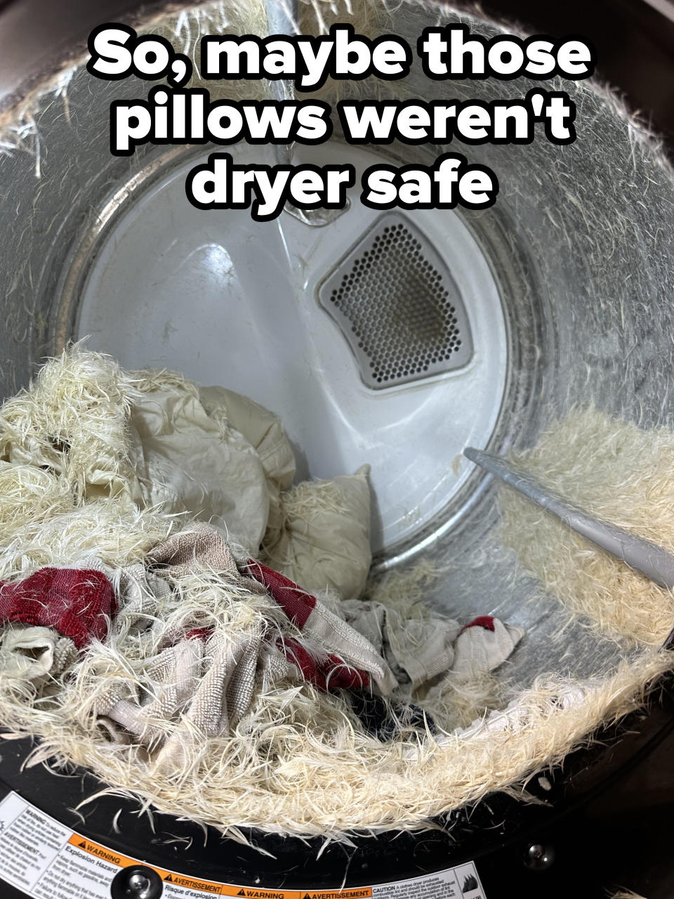 A washing machine drum filled with lint and a few pieces of fabric