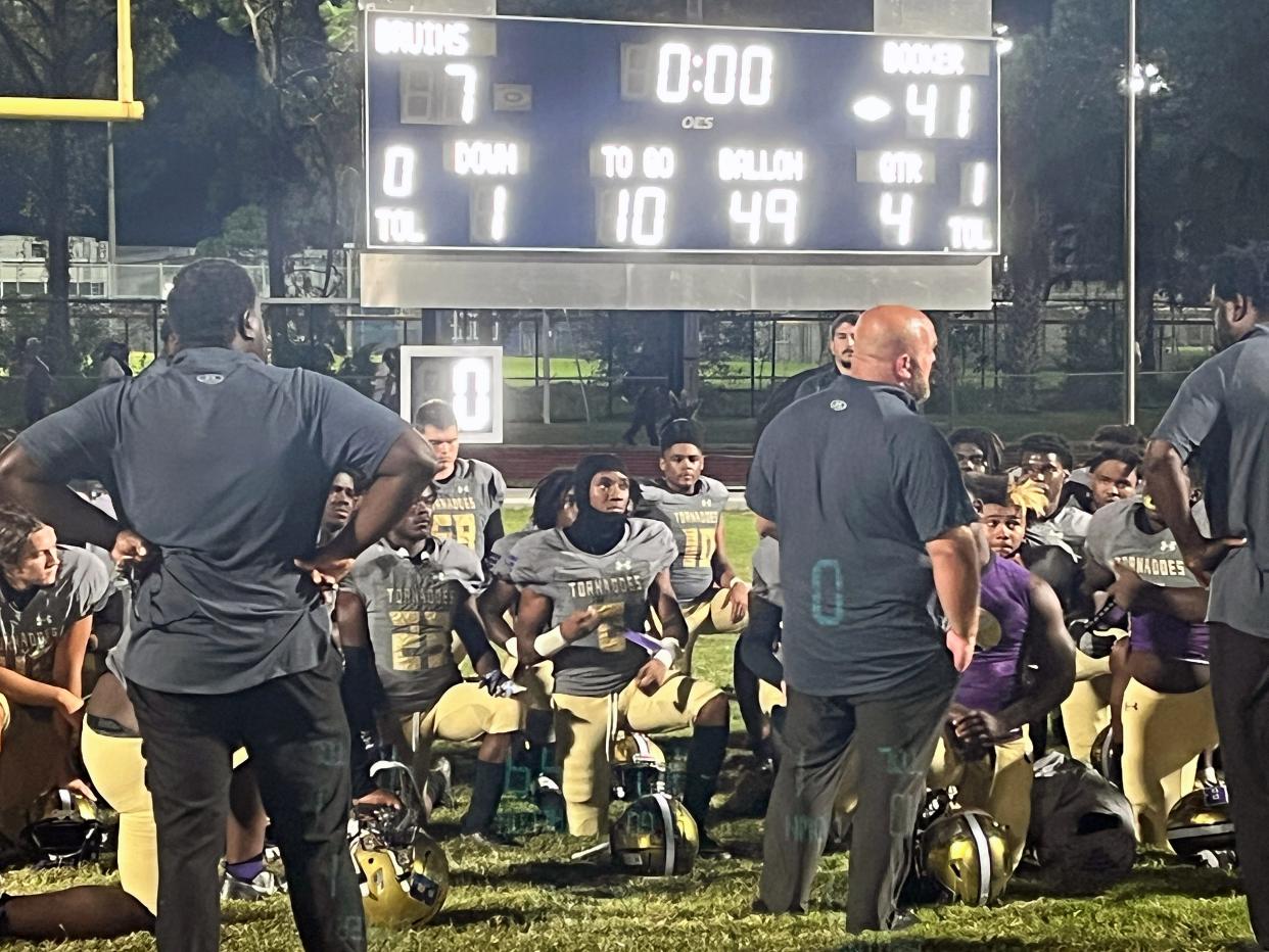 Booker High football coach Scottie Littles speaks with his team after a 41-7 victory over Bayshore High on Tuesday night at Balvanz Stadium in Bradenton.