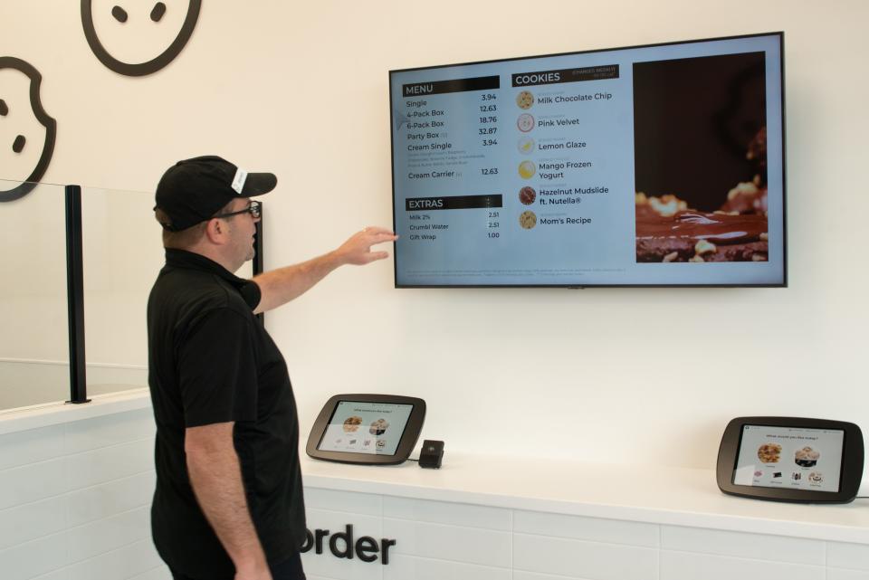 Customers ordering from Crumbl Cookies are directed to a self-ordering station, where they can choose from a selection of cookies, ice cream and extras before picking up their order down the counter. Each Sunday evening, the new flavors of cookies that will make up each store's lineup for the week are revealed on social media.