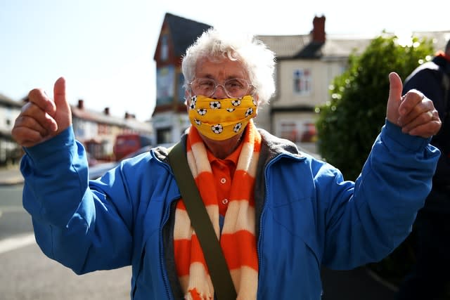 A Blackpool fan wearing a football patterned face mask poses on the way into the League One match against Swindon 