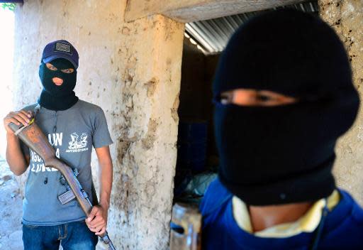 Dos exinformantes del cartel Los Templarios posan durante una entrevista con la AFP en La Nopalera, Michoacán, el 15 de febrero de 2014 (AFP | Alfredo Estrella)