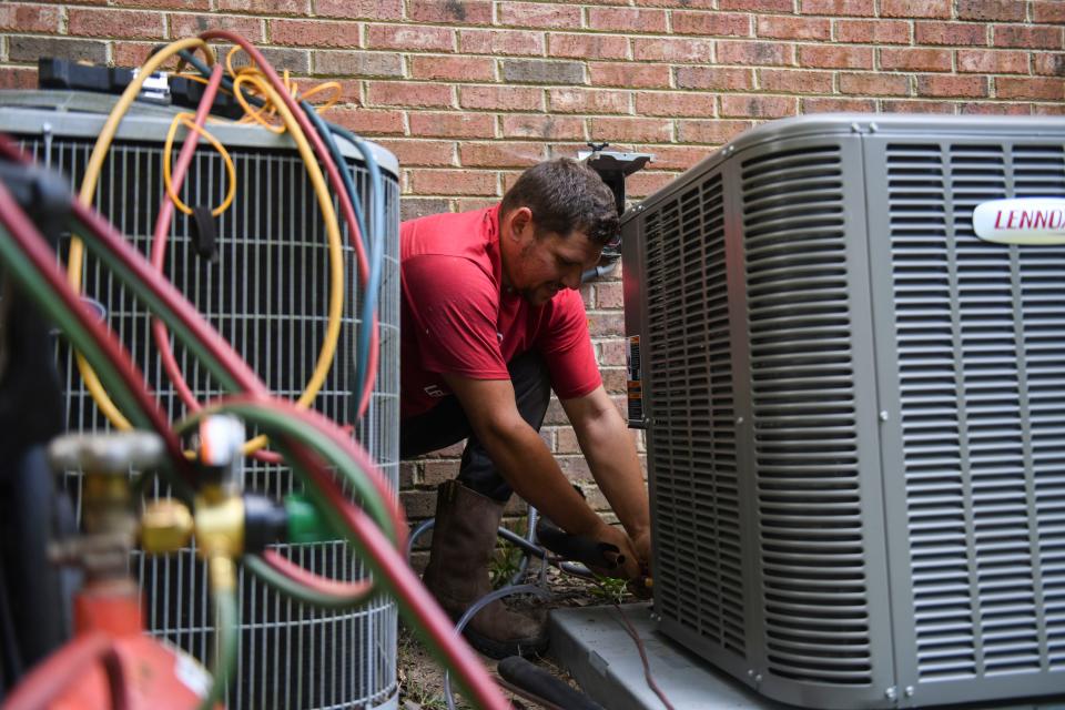 Sig Cox employees install a free HVAC system outside Dr. Nicole Nelson's home on Tuesday, Oct. 10, 2023. Sig Cox partnered with Lennox as a part of their Feel the Love national give away.