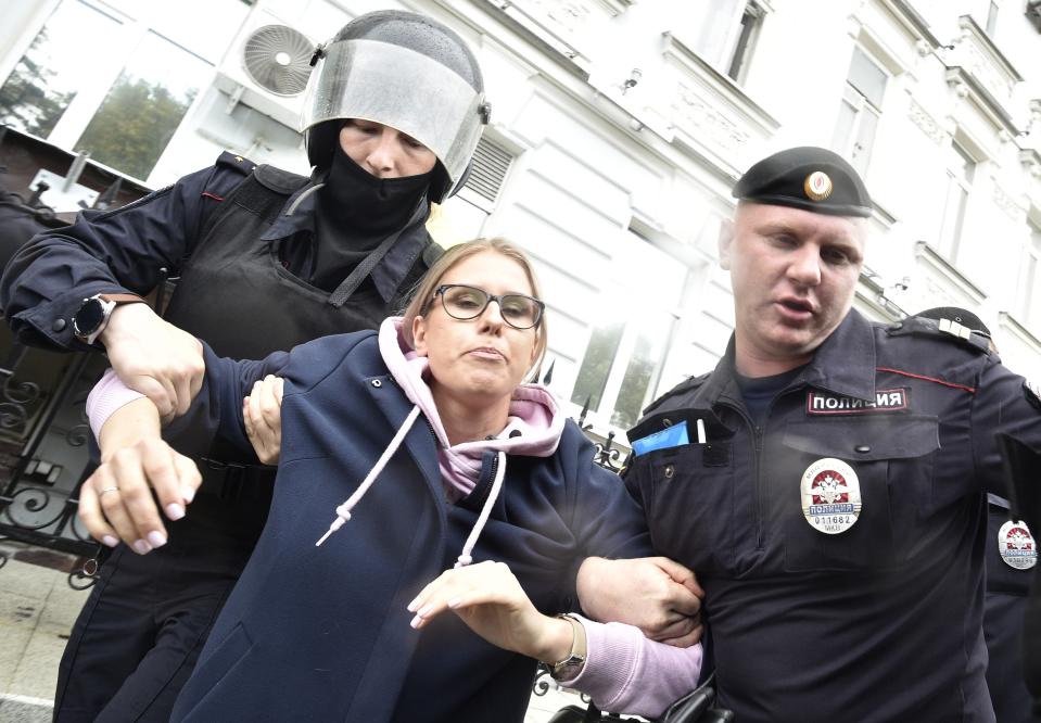 Police officers detain an opposition candidate and lawyer at the Foundation for Fighting Corruption Lyubov Sobol in the center of Moscow, Russia, Saturday, Aug. 3, 2019. (AP Photo/Dmitry Serebryakov)