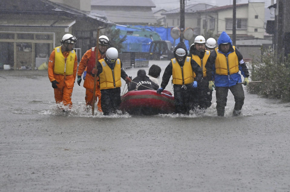 FILE - People are transferred by boat as a residential area is flooded due to heavy rain in Akita, northern Japan, July 15, 2023. Scientists say increasingly frequent and intense storms could unleash more rainfall in the future as the atmosphere warms and holds more moisture. (Kyodo News via AP, File)