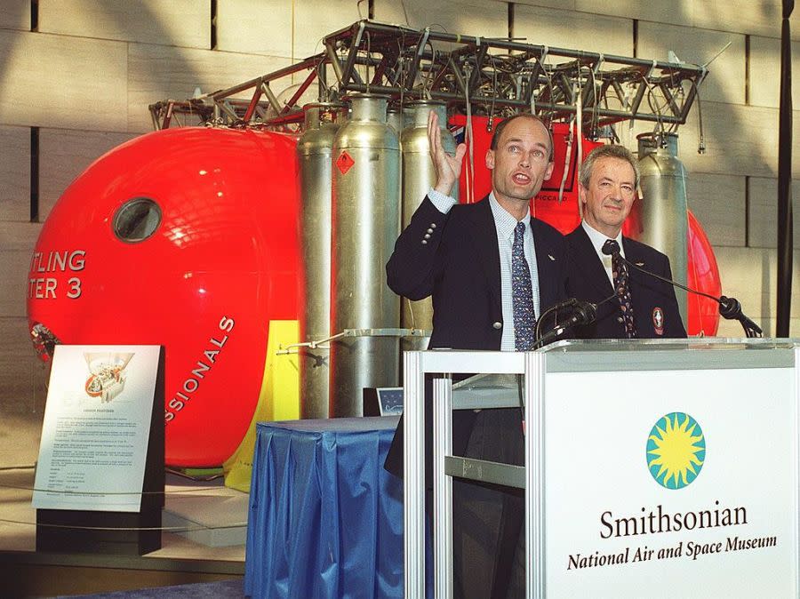 WASHINGTON, : Balloonists Bertrand Piccard (L) and Brian Jones participate in ceremonies 23 September, 1999 in which the gondola from their historic non-stop around-the-world flight will be put on display at the Smithsonian’s Air and Space Museum in Washington, DC. On 20 March,1999 the Breitling Orbiter 3 became the first balloon to achieve an around-the-world flight when Piccard and Jones flew 29,000 miles in 19 days, 21hours and 47 minutes.( CHRIS KLEPONIS/AFP via Getty Images)