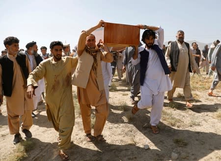 Men carry a coffin of one of the victims of a blast in a wedding, during a burial ceremony in Kabul