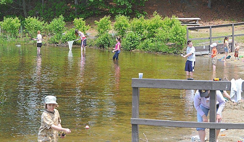 Kids line the shore of the beach at Watson Pond in Taunton for the annual fishing derby in this undated file photo.