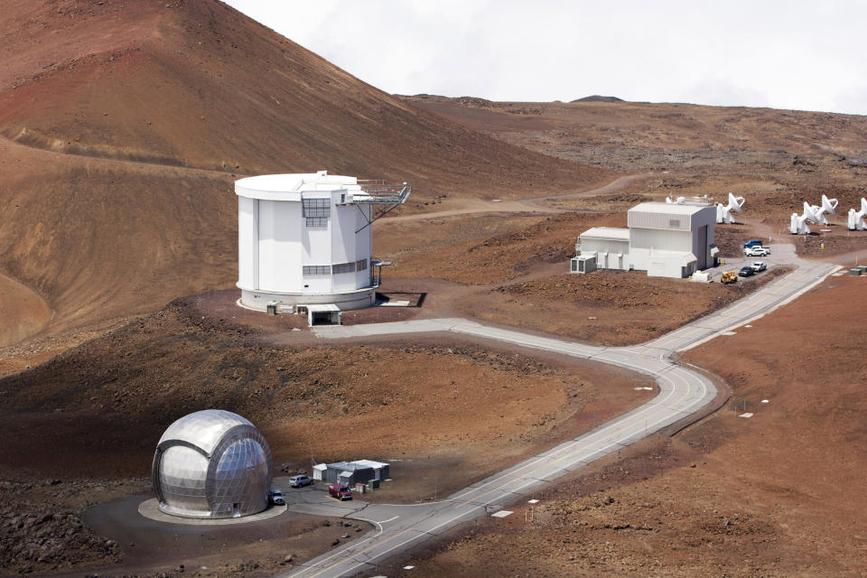 FILE - In this Aug. 31, 2015, file photo, from bottom left, the Caltech Submillimeter Observatory, the James Clerk Maxwell Telescope and the Submillimeter Array, far right, are shown on Hawaii's Mauna Kea near Hilo, Hawaii. Observatories on Hawaii's tallest mountain have shut down operations in response to the governor's stay-at-home order aimed at preventing the spread of the coronavirus. The Honolulu Star-Advertiser reported the shutdown of telescope operations on Mauna Kea is expected to affect more than 500 technicians, astronomers, instrument scientists, engineers, and support staff who work at the Big Island summit and at observatory bases below. (AP Photo/Caleb Jones, File)