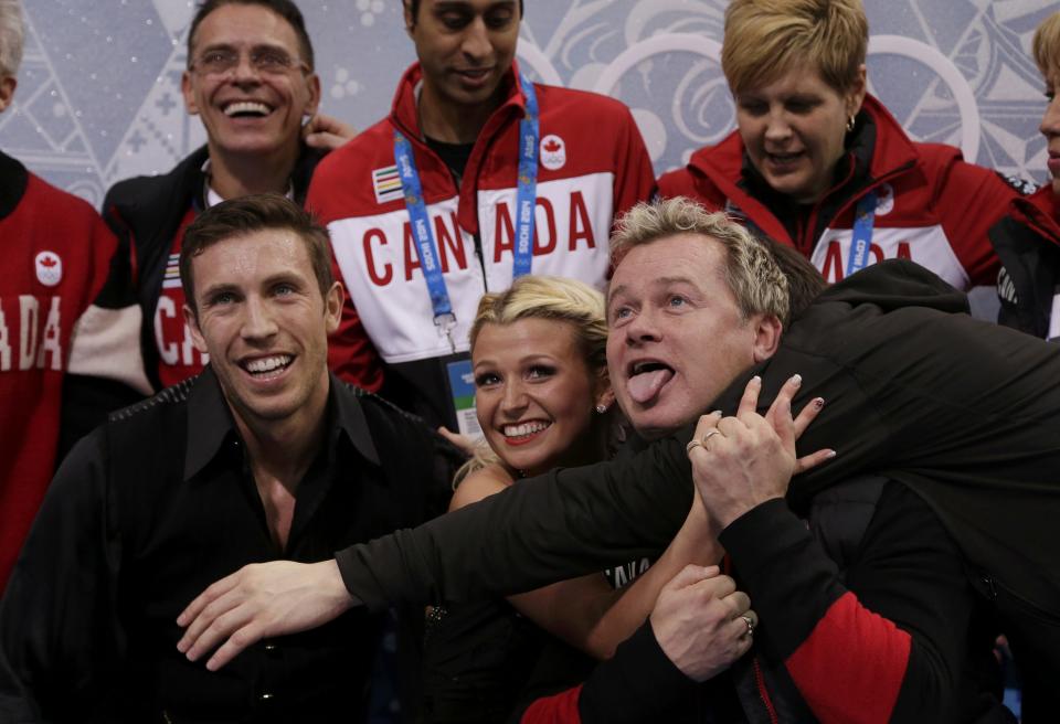 Kirsten Moore-Towers and Dylan Moscovitch (L) of Canada react with their coach Kris Wirtz (R) and teammates in the "kiss and cry" area during the Team Pairs Free Skating Program at the Sochi 2014 Winter Olympics, February 8, 2014. REUTERS/Darron Cummings/Pool (RUSSIA - Tags: SPORT FIGURE SKATING SPORT OLYMPICS)