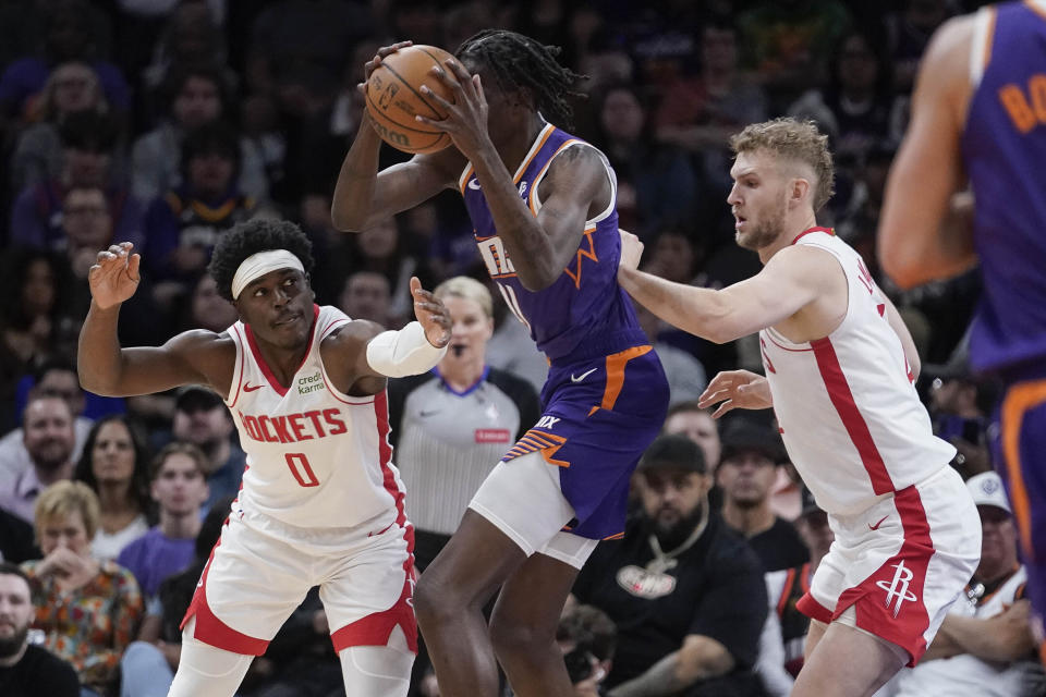 Houston Rockets guard Aaron Holiday (0) and center Jock Landale (2) double-team Phoenix Suns center Bol Bol, center, during the first half of an NBA basketball game in Phoenix, Saturday, March. 2, 2024. (AP Photo/Darryl Webb)