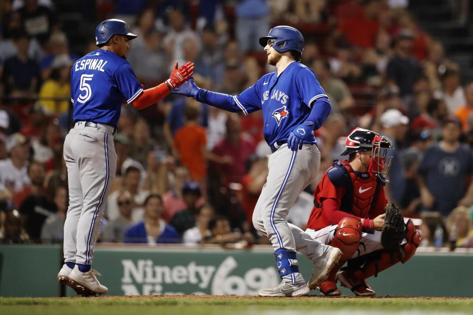 Toronto Blue Jays' Danny Jansen, center, celebrates after driving in Santiago Espinal, left, with a home run against the Boston Red Sox during the sixth inning of a baseball game Friday, July 22, 2022, in Boston. (AP Photo/Michael Dwyer)