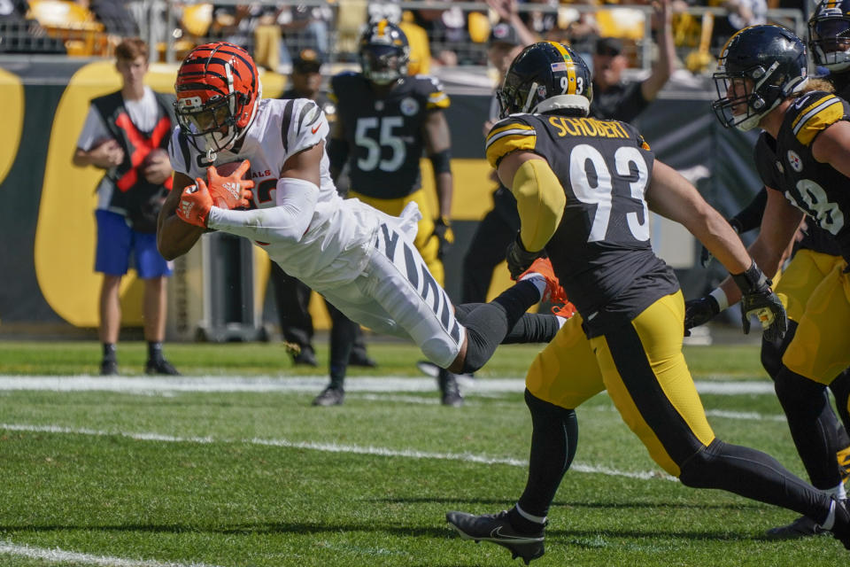 Cincinnati Bengals wide receiver Tyler Boyd (83) dives past Pittsburgh Steelers inside linebacker Joe Schobert (93) for a touchdown during the first half an NFL football game, Sunday, Sept. 26, 2021, in Pittsburgh. (AP Photo/Gene J. Puskar)