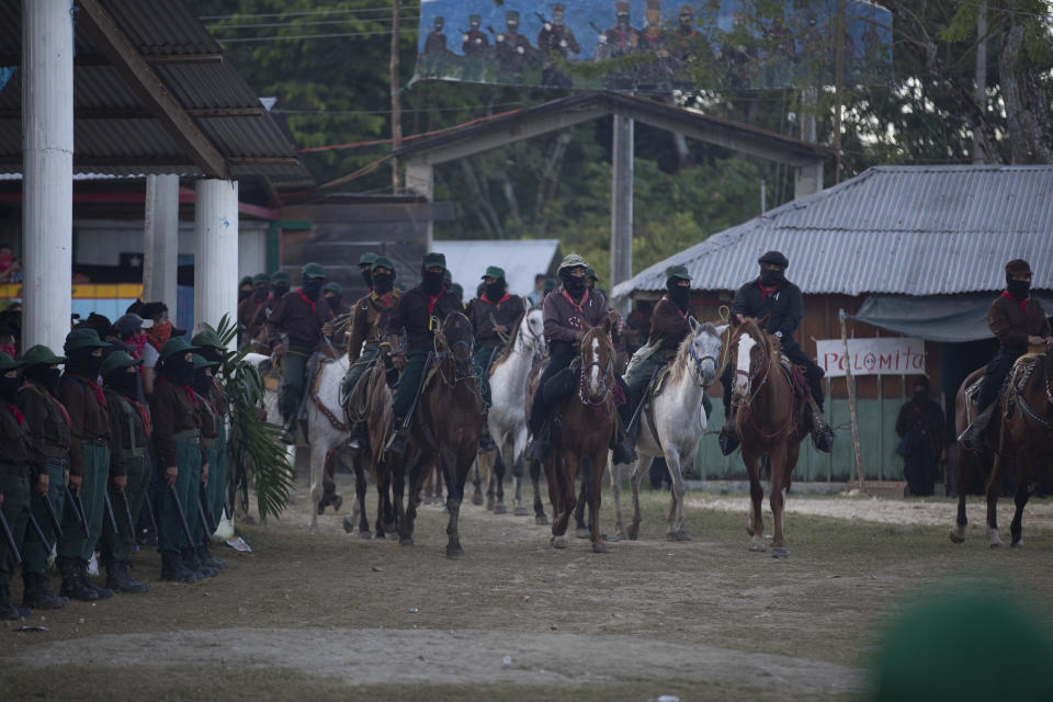 Leaders of the Zapatista National Liberation Army, EZLN, arrive on horseback to an event marking the 25th anniversary of the Zapatista uprising, in La Realidad, Chiapas state, Mexico, late Monday, Dec. 31, 2018. (AP Photo/Eduardo Verdugo)