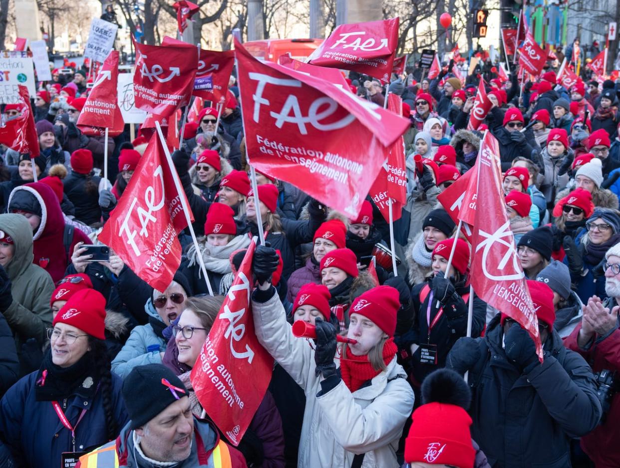 Striking teachers and their supporters hold a rally in front of Premier François Legault's office in Montreal Friday. (Ryan Remiorz/The Canadian Press - image credit)