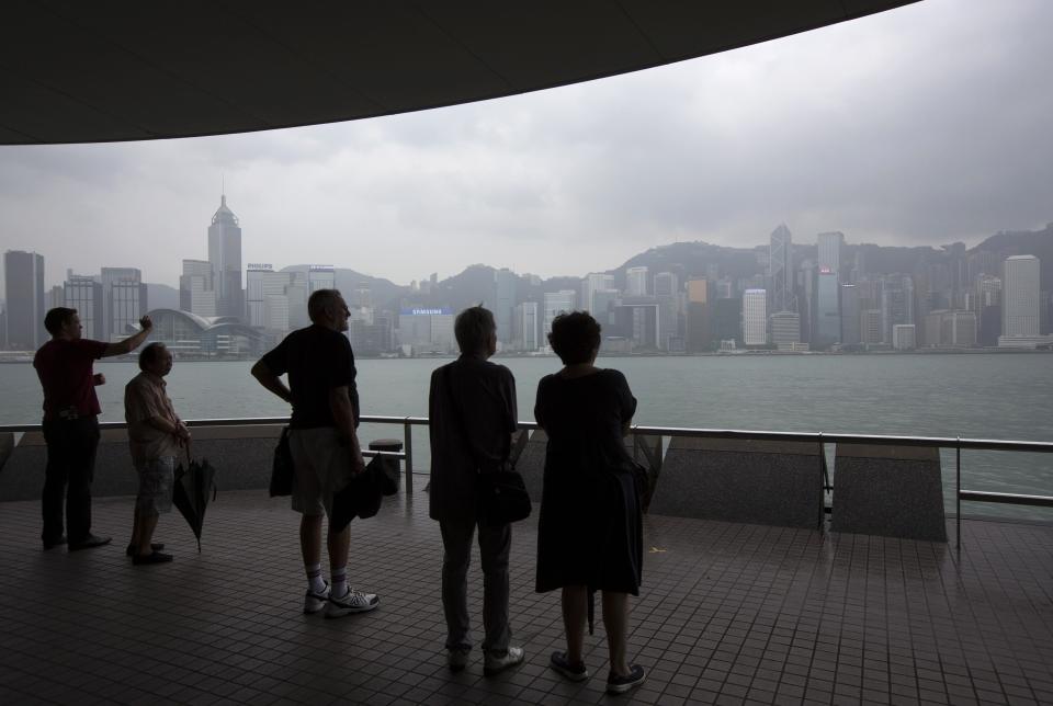 People look at the city skyline by Tsim Sha Tsui waterfront hours before Typhoon Usagi is expected to make landfall, in Hong Kong