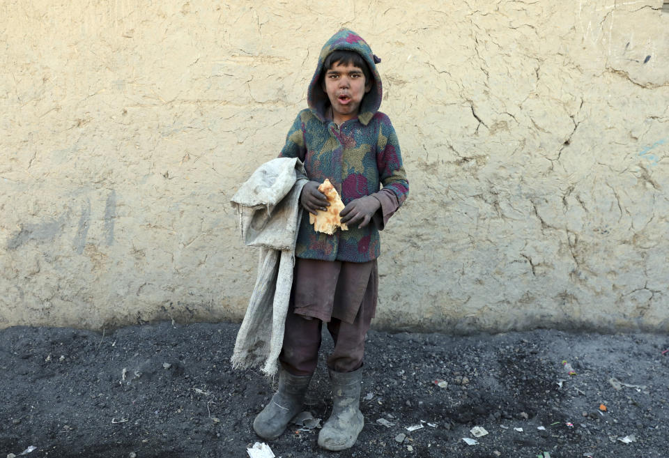An internally displaced boy poses for a photograph outside his temporary home in the city of Kabul, Afghanistan, Wednesday, Dec. 30, 2020. Save the Children has warned that more than 300,000 Afghan children face freezing winter conditions that could lead to illness, in the worst cases death, without proper winter clothing and heating. (AP Photo/Rahmat Gul)