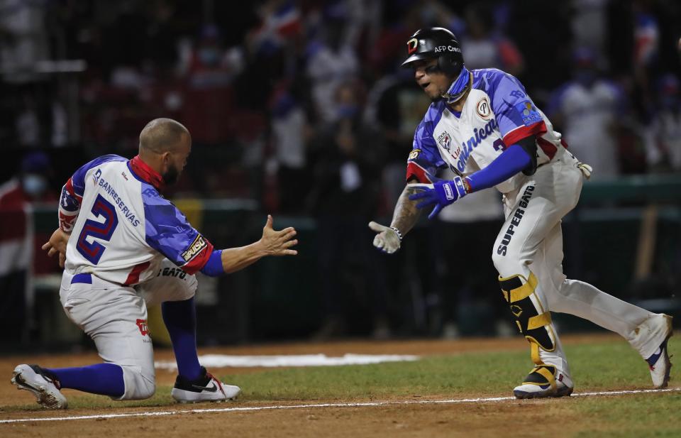 Johan Camargo (derecha) celebra con Juan Carlos Pérez tras batear un jonrón para las Águilas Cibaeñas de República Dominicana durante el quinto inning de la victoria 4-1 ante los Criollos de Caguas de Puerto Rico en la final jugada en Mazatlán, México, el sábado 6 de febrero de 2021. (AP Foto/Moisés Castillo)