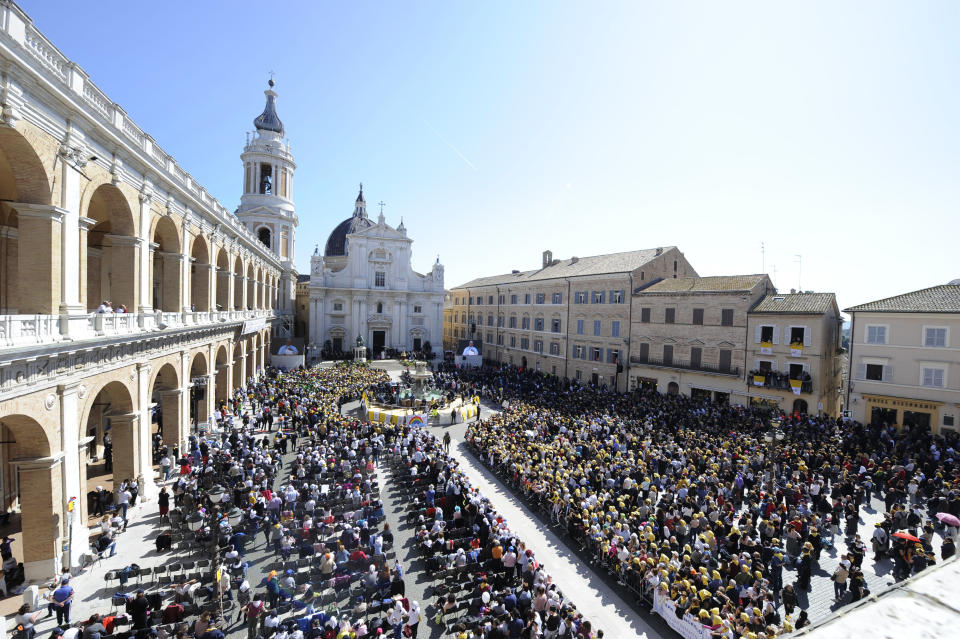 Pope Francis seen on a giant screens in the background, celebrates Mass outside Loreto's cathedral, central Italy, Monday, March 25, 2019. Francis has traveled to a major Italian pilgrimage site dedicated to the Virgin Mary to sign a new document dedicated to today's youth. (AP Photo/Sandro Perozzi)