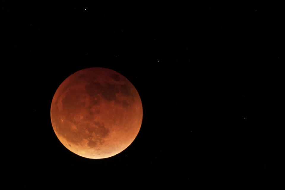 FILE - The moon is shown during a full lunar eclipse, Sunday, May 15, 2022, near Moscow, Idaho, with the reddish color caused by it passing into the shadow of the Earth. A Tuesday, Nov. 8, 2022 total lunar eclipse will be visible throughout North America in the predawn hours _ the farther west, the better _ and across Asia, Australia and the rest of the Pacific after sunset. (AP Photo/Ted S. Warren, File)