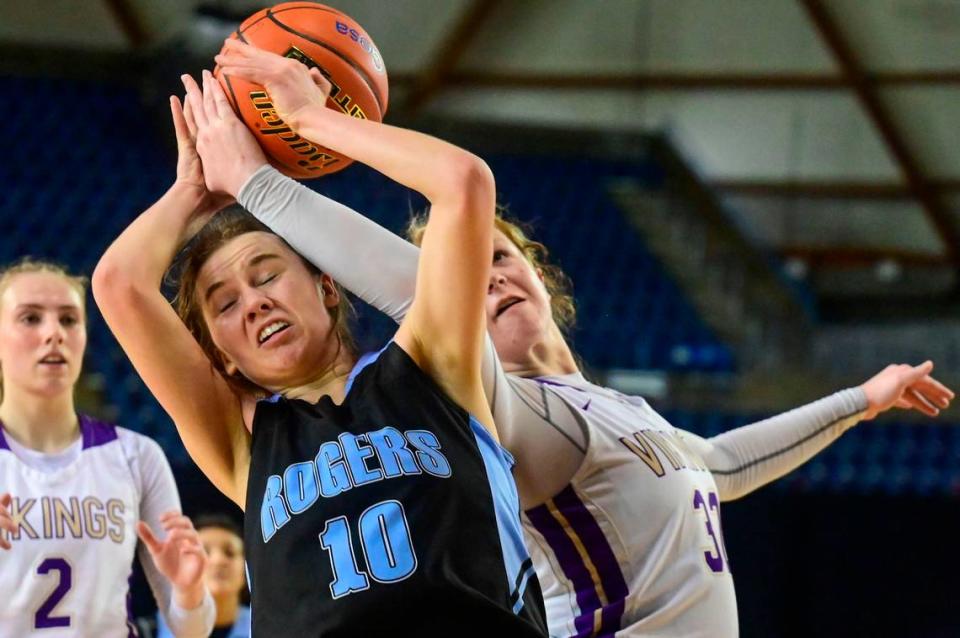 Rogers forward Alexa Caufield (10) and Lake Stevens forward Cori Wilcox (32) fight for a rebound during overtime of a Class 4A state tournament game on Wednesday, March 2, 2022, at the Tacoma Dome, in Tacoma, Wash.
