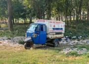 A three-wheeled vehicle used for waste disposal is seen parked near the perimeter wall of the Jawaharlal Nehru Medical College and Hospital in Bhagalpur