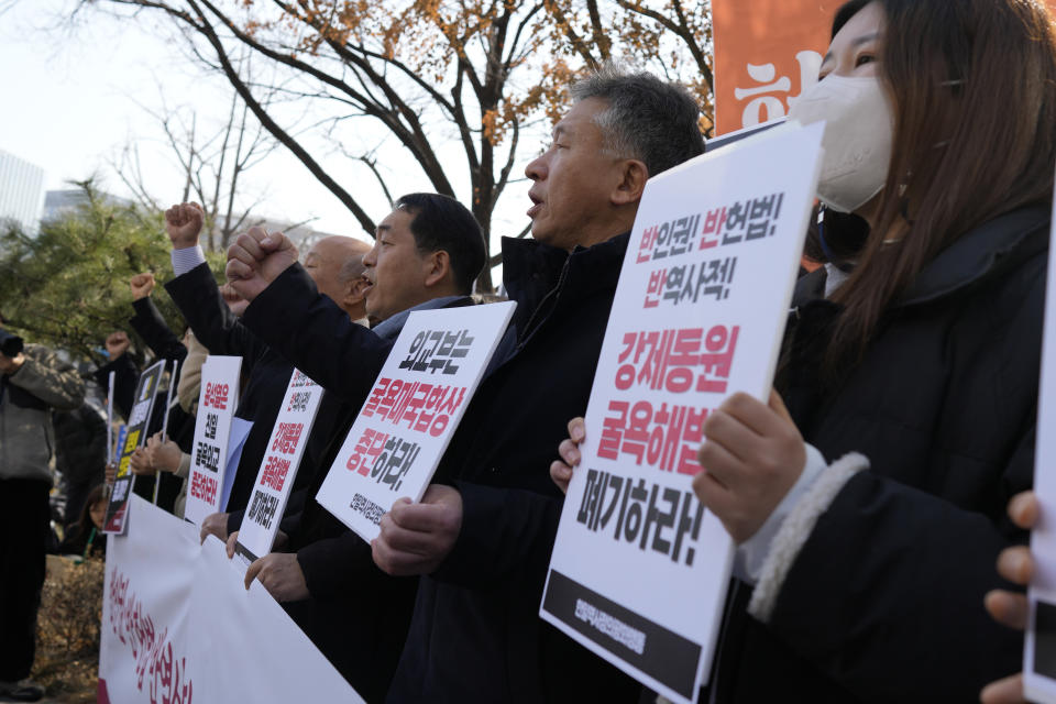 Members of civic groups shout slogans during a rally against the South Korean government's announcement of a plan over the issue of compensation for forced labors, in front of the Foreign Ministry in Seoul, South Korea, Monday, March 6, 2023. South Korea on Monday announced a contentious plan to raise local civilian funds to compensate Koreans who won damages in lawsuits against Japanese companies that enslaved them during Tokyo's 35-year colonial rule of the Korean Peninsula. A banner reads "Discards humiliating solution to forced labor issue." (AP Photo/Lee Jin-man)