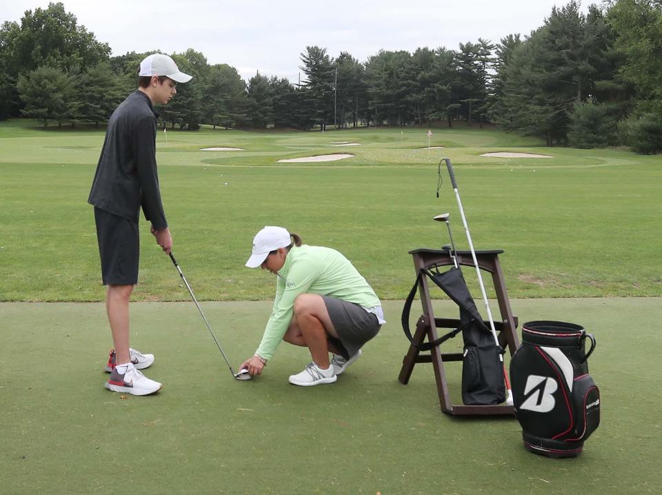 Huston Nagy, 16, of North Olmsted, who is blind, waits for coach Erin Craig to tap the golf ball on the seven iron he is using at the driving range at Firestone Country Club on Monday in Akron.