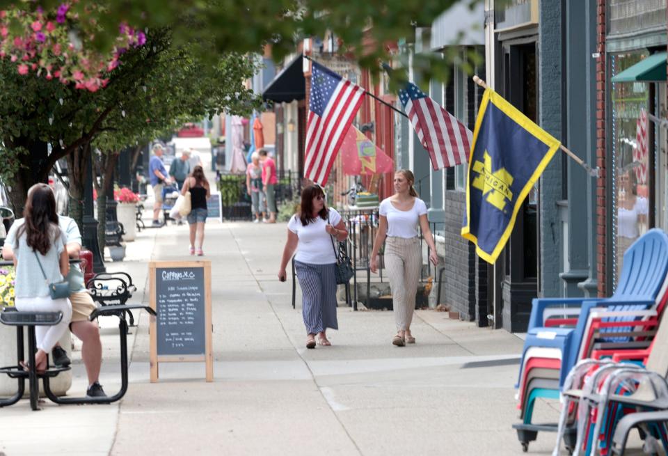 People walk in downtown Marshall on Wednesday, July 12, 2023. The controversial construction of the Ford electric vehicle battery plant less than 5 miles from this area has some residents divided on the support of the factory that is supposed to bring at least 2,500 jobs to the area.