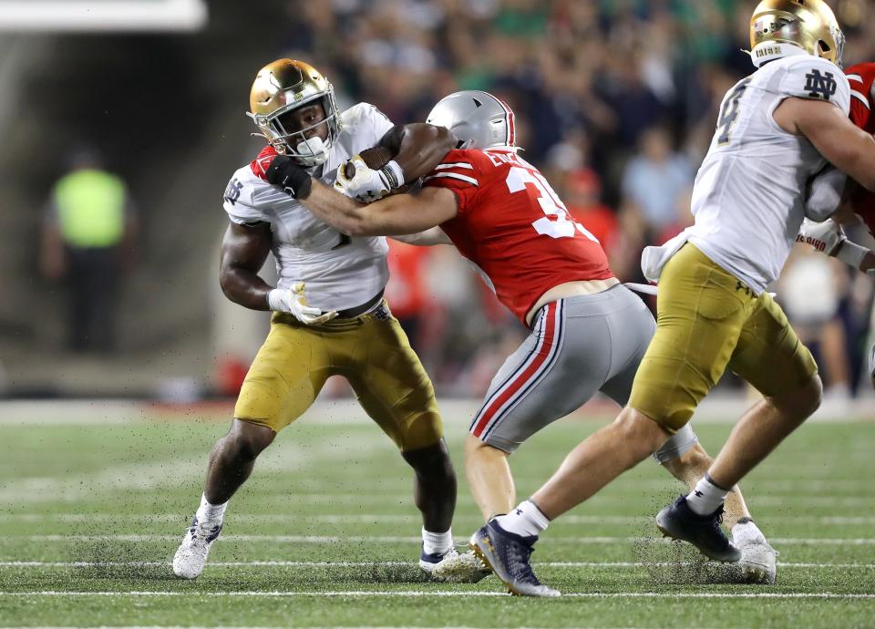 Notre Dame running back Audric Estime (7) runs the ball as Ohio State defensive end Jack Sawyer (33) makes the tackle during the third quarter at Ohio Stadium.