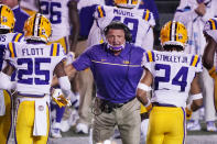 FILE - In this Oct. 3, 2020, file photo, LSU head coach Ed Orgeron congratulates players after a score against Vanderbilt in the second half of an NCAA college football game in Nashville, Tenn. Coaches wearing masks around their chins. Fans not wearing masks at all while cheering from their seats. One school deciding to drop the safety checks it was requiring for those entering the stadium to cut down on long lines. College football is sending plenty of alarming signals at it attempts to get through a tenuous season amid a pandemic. (AP Photo/Mark Humphrey, File)