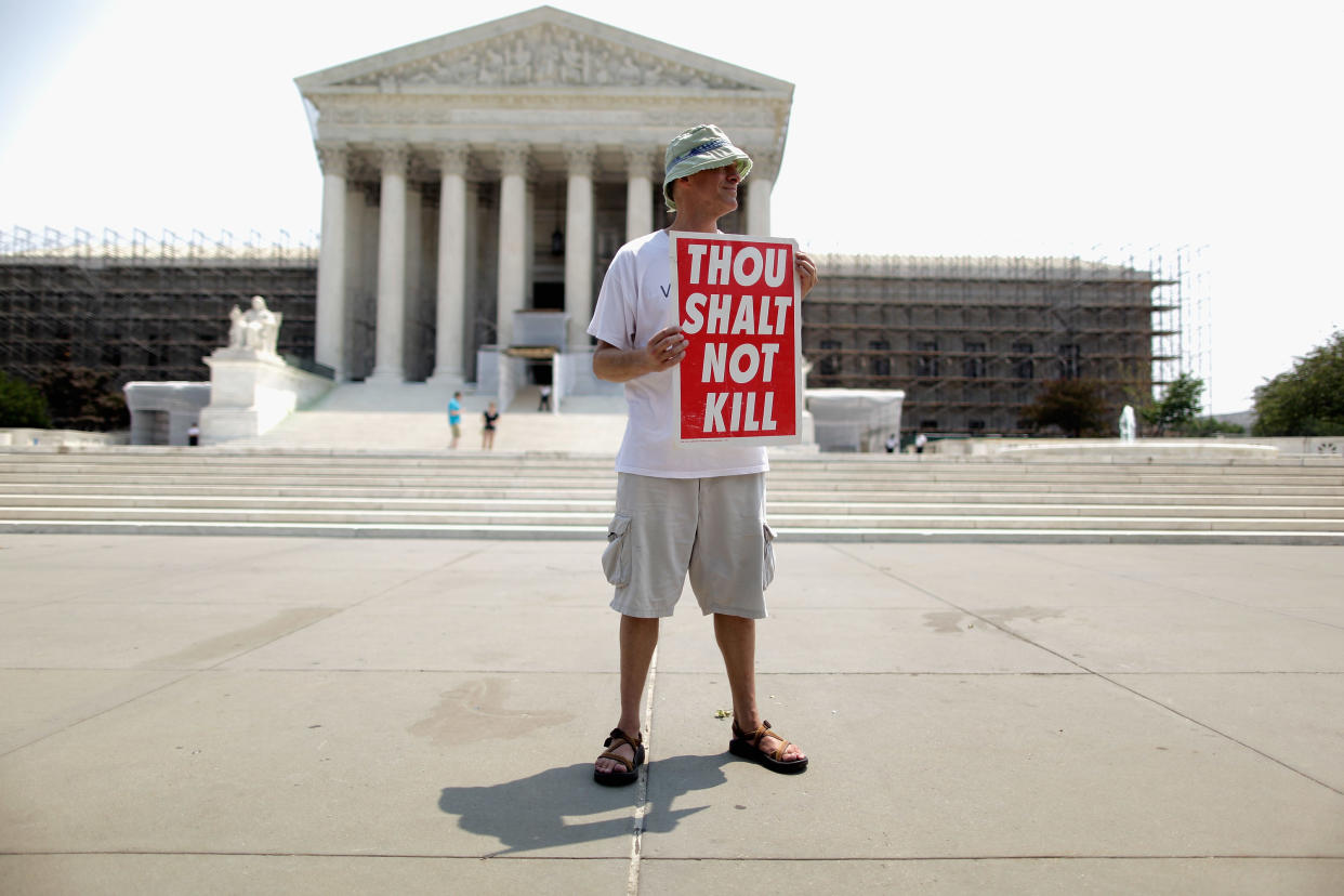 An anti-death penalty activist with a sign saying: Thou shalt not kill.