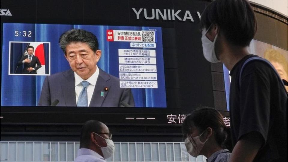 Personas observan una pantalla en Shinjuku que muestra al primer ministro Shinzo Abe
