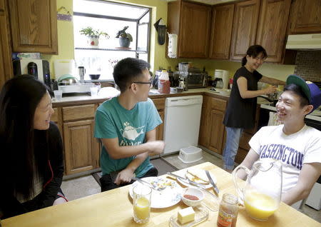 Un Bang (2nd R) prepares food as her sons Simon, 18, and Shane Bang (2nd L), 21, and Shane's girlfriend Sarah Park (L), 20, spend time at their home in Federal Way, Washington August 8, 2015. REUTERS/Jason Redmond