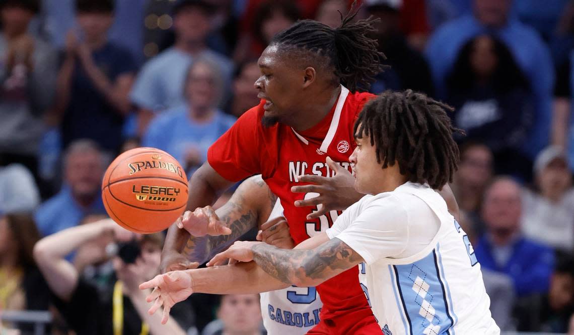 North Carolina’s Elliot Cadeau (2) knocks the ball from N.C. State’s DJ Burns Jr. (30) during the first half of N.C. State’s game against UNC in the championship game of the 2024 ACC Men’s Basketball Tournament at Capital One Arena in Washington, D.C., Saturday, March 16, 2024.