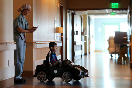 Doctor Daniela Carvalho controls Jonathan Jauregui, 7, remotely as Rady Children's Hospital unveil a program that uses remote control cars, donated by the local police officers charity, to take young patients to the operating room, in San Diego, California, U.S. September 19, 2017. REUTERS/Mike Blake