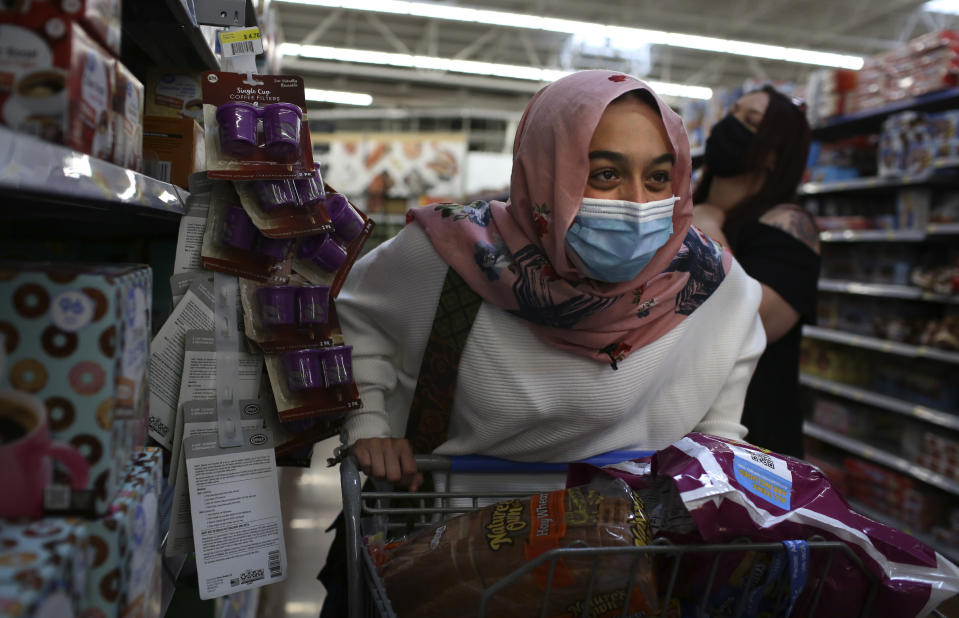 Amirah Ahmed, 17, pushes a cart while shopping with her family at a Walmart in Fredericksburg, Va., on Saturday, Aug. 14, 2021. (AP Photo/Jessie Wardarski)