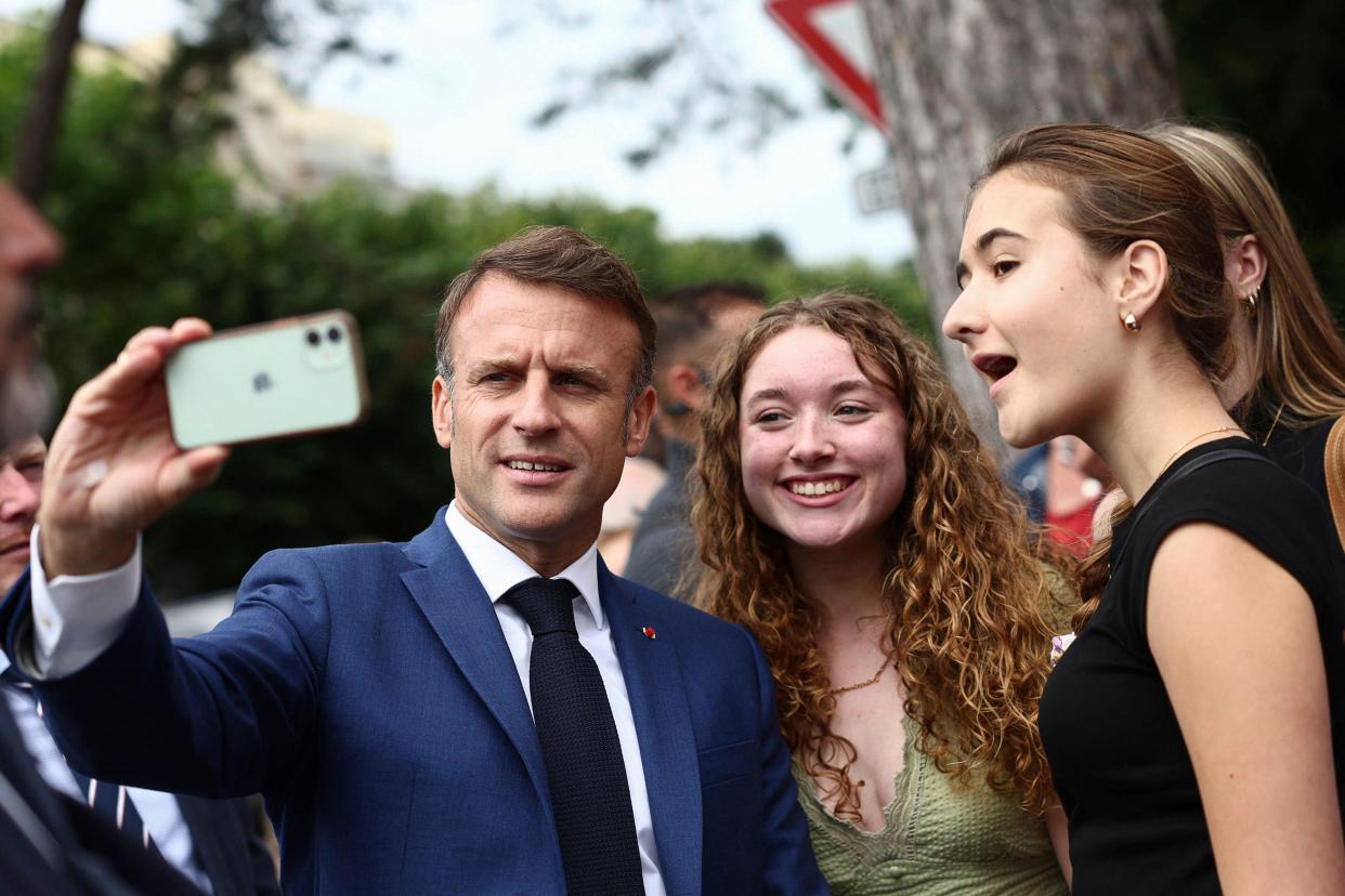 French President Emmanuel Macron takes a selfie with supporters after voting in Le Touquet-Paris-Plage, northern France, Sunday, June 30, 2024. France is holding the first round of an early parliamentary election that could bring the country's first far-right government since Nazi occupation during World War II. The second round is on July 7, and the outcome of the vote remains highly uncertain (Yara Nardi, Pool via AP)